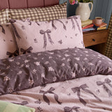 Belle Stripe Reversible Bows Duvet Cover Set in Rosewood, showing pink bow-print pinstripe side and reverse deep purple ditsy floral side with matching pillowcases.