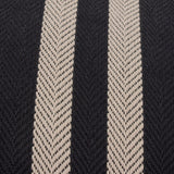 Close-up of the Benton Herringbone Cotton Cushion in black, showing woven herringbone twill texture with two off-centre pale stripes on a black cotton ground.