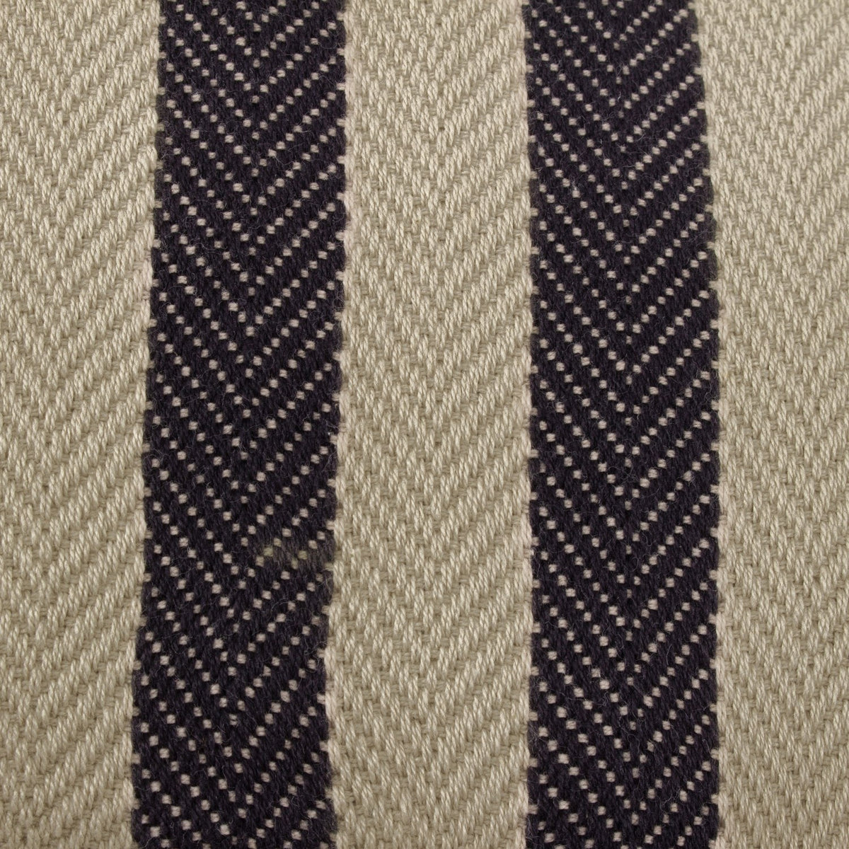 Close-up of the Benton Herringbone Cotton Cushion showing natural beige herringbone twill fabric with two dark contrast stripes running down the centre.