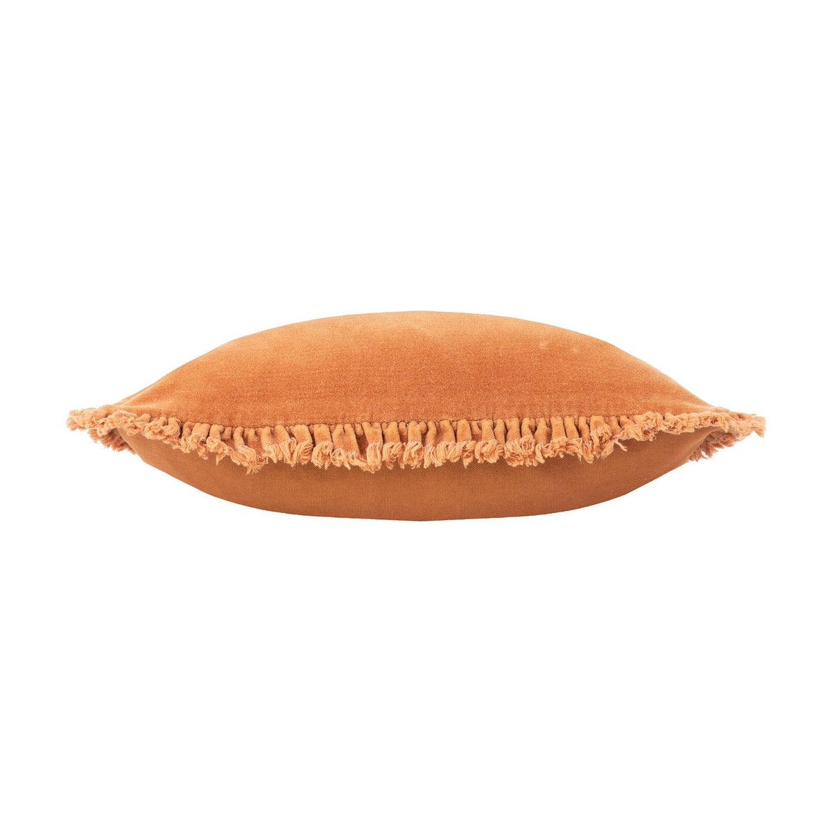 Bertie Velvet Cotton Cushion in rust, shown edge-on to reveal its plump square shape and frayed fringe trim along the seam, set against a white background.