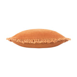 Bertie Velvet Cotton Cushion in rust, shown edge-on to reveal its plump square shape and frayed fringe trim along the seam, set against a white background.