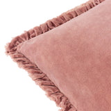 Close-up of the Bertie Velvet Cotton Cushion in rose pink, showing soft frayed ruffled edging and the velvet fabric's uneven, light-catching texture on a white background.