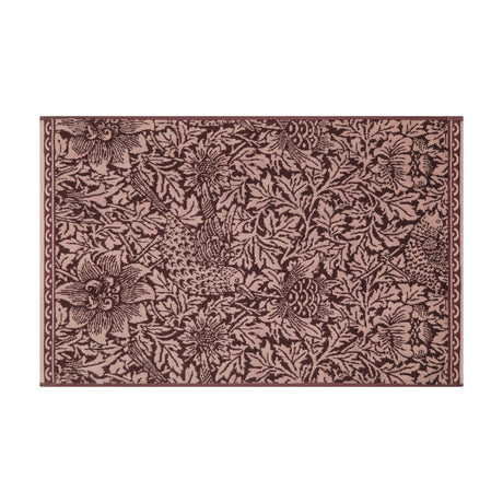 Rectangular cotton bath mat with Bird and Anemone floral pattern in two-tone plum, birds and leafy anemone motifs edge to edge, bordered trim, shown on a white background.
