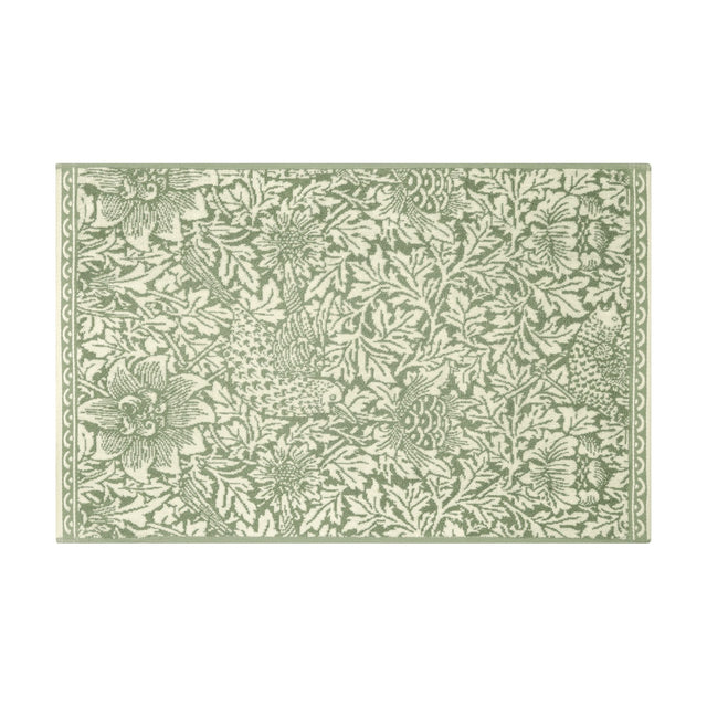 Rectangular cotton bath mat in the Bird and Anemone design, sage green birds, anemone flowers and foliage on a cream ground with a scrolled border, shown on a white background.