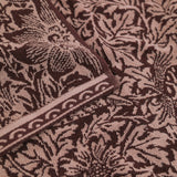 Close-up of the Bird & Anemone Jacquard Cotton Towel in plum, showing the woven bird and floral pattern in aubergine and dusky rose with a scalloped border trim.