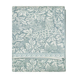 Folded Bird & Anemone jacquard cotton towel in slate blue with woven bird and foliage pattern and scalloped border trim, shown on a plain white background.