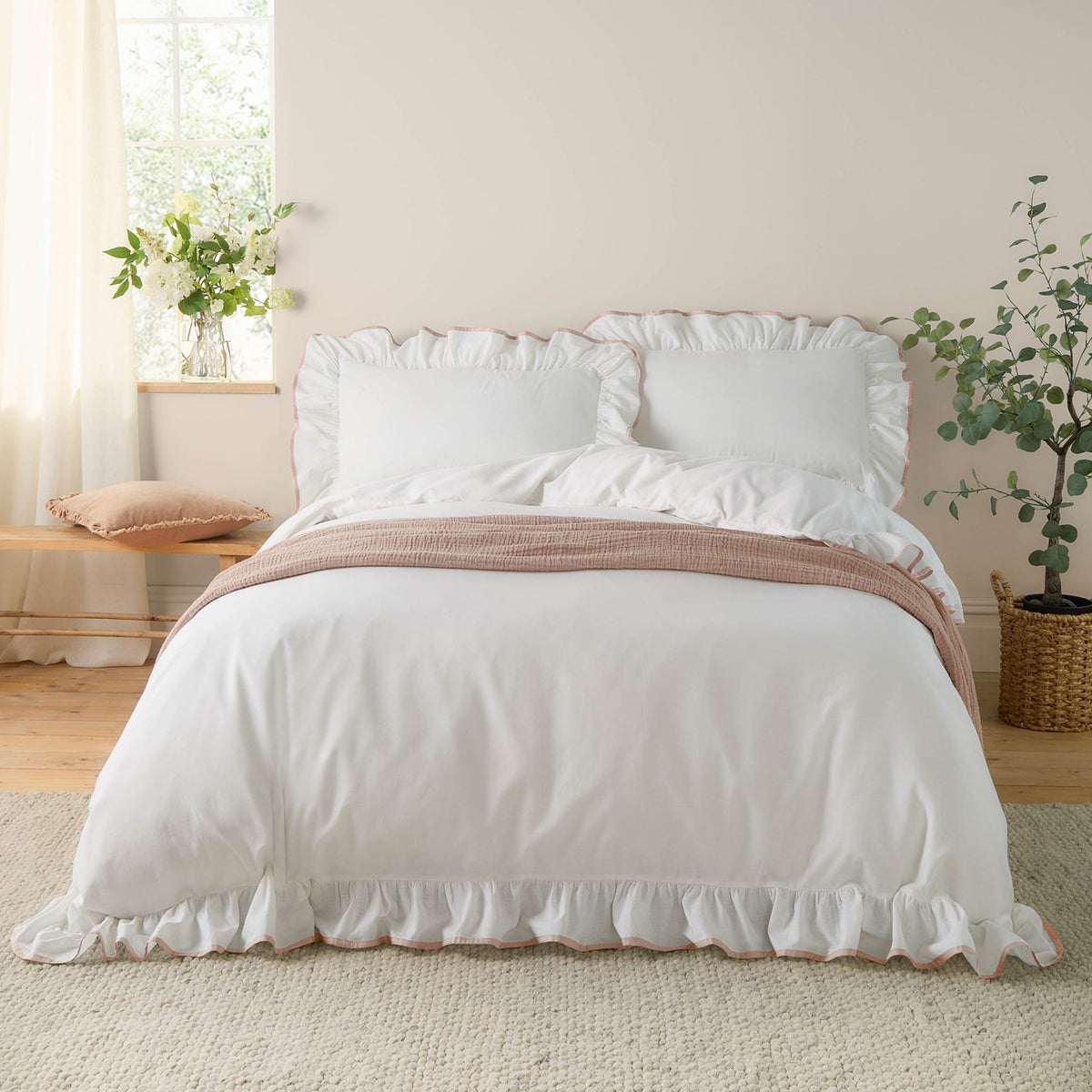 Blousey Cotton Plain Duvet Cover Set in white with pink piped ruffle trim, styled on a bed with matching pillowcases in a bright bedroom setting.
