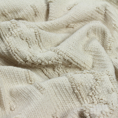 Close-up of the Boho Geometric Cotton Throw in natural cream, showing raised tufted geometric bands woven into the textured cotton fabric.