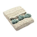 Boho Geometric Cotton Throw in cream with raised tufted geometric patterning and seafoam green tassel trim, folded on a plain white background.