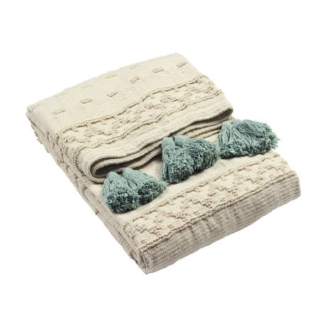 Boho Geometric Cotton Throw in cream with raised tufted geometric patterning and seafoam green tassel trim, folded on a plain white background.
