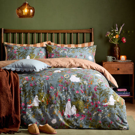 Multicolour Bootanical Forest Duvet Cover Set on a bed with grey-blue floral, pink and white blooms and ghost motifs, reverse rust-and-cream stripe, styled in a green bedroom.