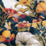 Close-up of the Bootanical Floral Polyester Throw, showing an autumnal floral print in deep teal, gold, rust and cream on soft fleece fabric.