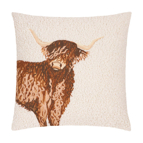 Square natural boucle cushion embroidered with a shaggy Highland cow in brown and tan tones with pale horns, shown on a plain white background.