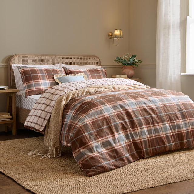 Braemar Check cotton reversible duvet cover set in chocolate and blue plaid, styled on a bed with matching pillowcases in a neutral bedroom setting.
