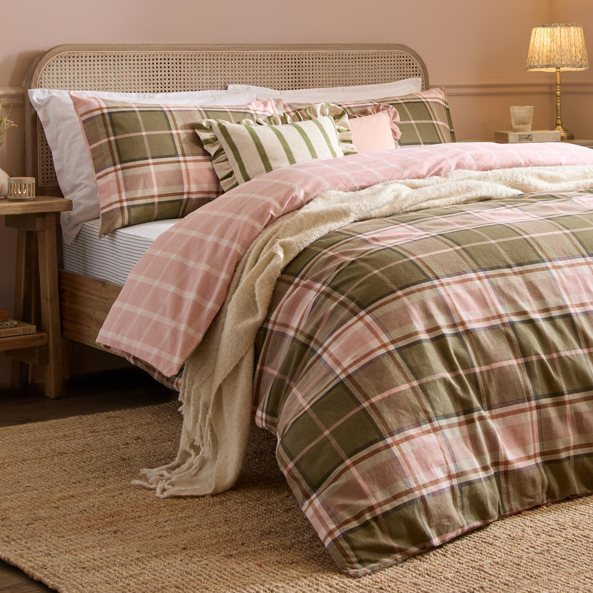 Braemar Check reversible cotton duvet cover set in green and pink tartan-style check, styled on a bed with matching pillowcases, cushions and a cream throw.