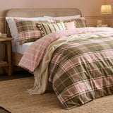 Braemar Check reversible cotton duvet cover set in green and pink tartan-style check, styled on a bed with matching pillowcases, cushions and a cream throw.