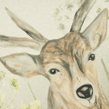 Close-up of the Bramble Stag cushion's polyester print, showing a hand-painted stag's head with antlers, ears and eyes in natural brown and cream tones against a meadow flower backdrop.