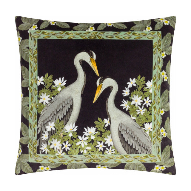 Braywick Animal Velvet Cushion in black polyester velvet, printed with two grey cranes facing each other, bordered by green leaves and white flowers on a plain background.