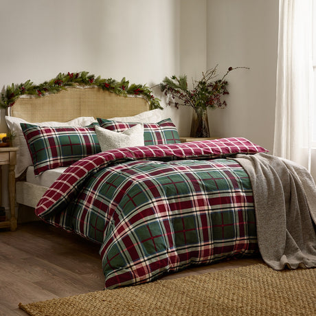 Braemar Check Cotton Reversible Duvet Cover Set in Berry/Pine on a bed with matching pillowcases, green tartan check reverse, cream cushion, and grey throw in a bedroom setting.