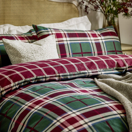 Braemar Check reversible brushed cotton duvet cover set in Berry/Pine tartan, shown on a bed with matching pillowcases and white and grey cushions in a bedroom setting.