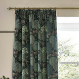 Brook Jacquard pencil pleat curtains in forest green polyester with woodland deer and tree pattern, hung on a brass rod beside a window.