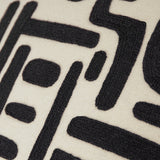 Close-up of the Brooke Abstract Cotton Cushion in Mono, showing black embroidered geometric bars, blocks and curved shapes on natural cream cotton.