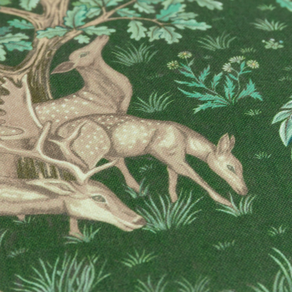 Close-up of The Brook jacquard polyester cushion in forest green, showing woven deer, oak leaves, and foliage detail in a woodland tapestry design.
