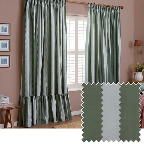 Birdie Stripe cotton pencil pleat curtains in bay green and mist, with wavy scalloped stripes and a gathered ruffle hem, shown hanging in a pink-toned living room window.