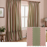 Birdie Stripe cotton pencil pleat curtains in pink and sage green vertical stripes with scalloped edging, shown pencil-pleated on a wooden pole in a bedroom, with a fabric swatch inset.