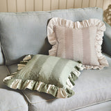 Birdie Stripe Frill Trim Cotton Cushion in Bay Green with a ruffled edge, shown alongside a mist-toned striped cushion on a pale blue sofa.
