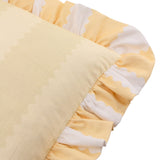 Birdie Stripe cotton cushion in butter yellow, close-up of the gathered scalloped frill trim in yellow and white against a plain background.