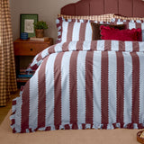 Birdie Stripe Printed Frill Trim Duvet Cover Set in blue and chocolate, styled on a bed with scalloped ruffled edges, velvet cushions, and a wooden bedside table in a bedroom setting.