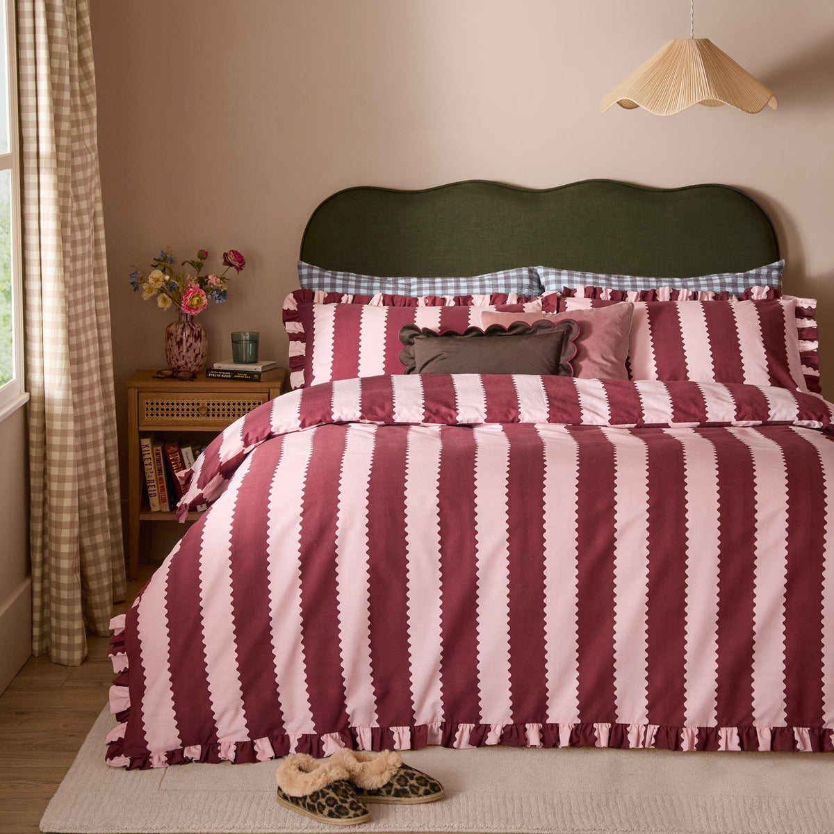 Birdie Stripe Frill Trim Duvet Cover Set in burgundy and blossom pink, styled on a bed with ruffled edges and coordinating scalloped pillowcases in a rustic bedroom setting.