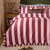 Birdie Stripe Frill Trim Duvet Cover Set in Burgundy/Blossom, featuring bold two-tone striped bedding with ruffled edges and scatter cushions, styled on a bed in a bedroom setting.