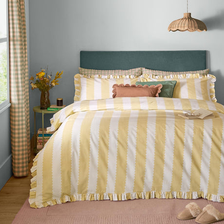Birdie Stripe Cotton Frill Trim Duvet Cover Set in butter yellow, shown on a bed with matching pillowcases and ruffle-trimmed edges in a bedroom with teal headboard.