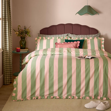 Bedroom scene with the Birdie Stripe Cotton Frill Trim Duvet Cover Set in green and pink, featuring scalloped stripe edging and a gathered frill trim on the duvet cover and pillowcases.