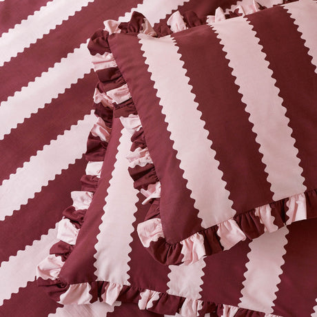 Birdie Stripe Cotton Blend Pillowcase Pair in Burgundy/Blossom, featuring wide burgundy and pink stripes with zigzag rickrack edging and a gathered ruffle border.