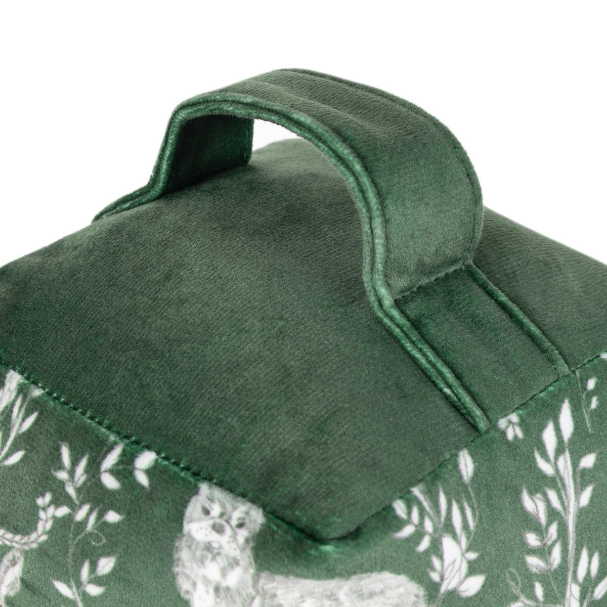 Close-up of the Buckthorn Animal Velvet Door Stop in evergreen, showing the plain velvet top with stitched carry handle above a woodland animal print side panel, on a white background.