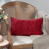 Buxton Reversible Polyester Cushion in red, a rectangular chenille-textured cushion resting on a cane-back chair with a beige throw and cream seat cushion.