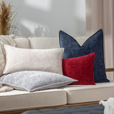 Buxton Reversible Polyester Cushion in red with a textured chenille-like weave, styled on a beige sofa alongside navy, grey, and cream cushions.