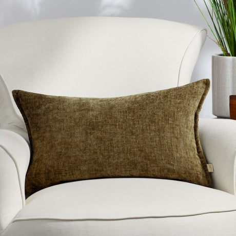 Buxton Reversible Polyester Cushion in Sage, a rectangular lumbar cushion in muted olive-green woven fabric with subtle sheen, shown on a white armchair.
