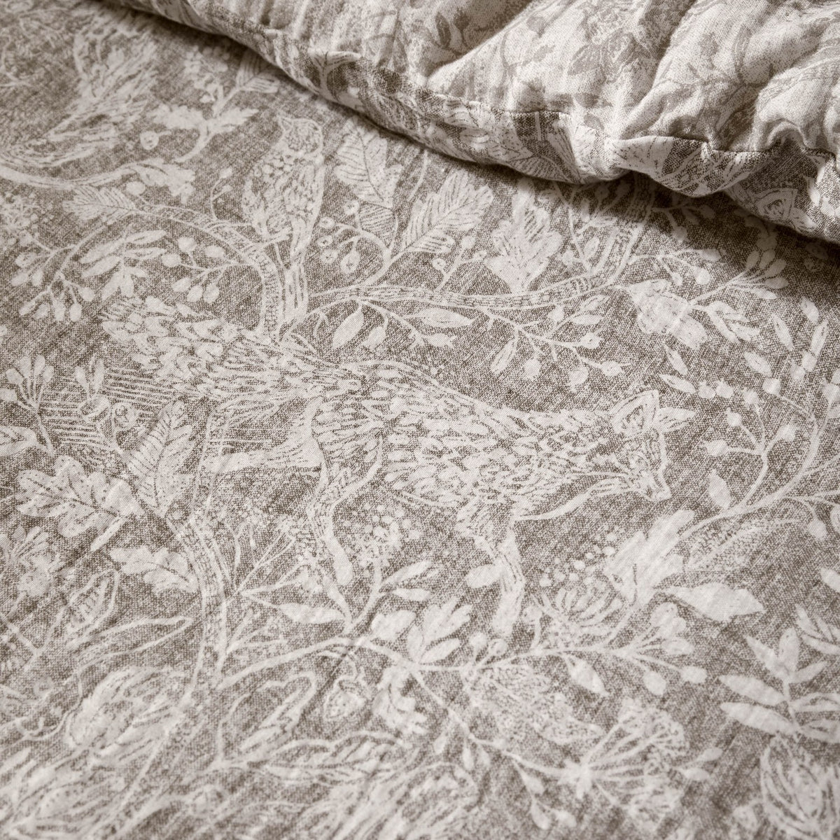 Cademuir Cotton Woodland Duvet Cover Set in Nut, close-up of muslin cotton fabric with fox, birds and foliage toile print in off-white on nutmeg-brown.