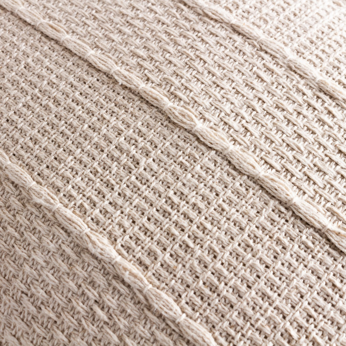 Close-up of the Caliche Plain Cotton Cushion in natural cream, showing woven cotton texture with braided stripes bordering alternating flat and open basket weave panels.