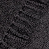 Close-up of the Candar Plain Polycotton Throw in black, showing looped boucle-woven texture with a hand-knotted fringe edge.