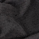 Close-up of the Candar Plain Polycotton Throw in black, showing its looped boucle-woven texture in a soft, nubbly weave.