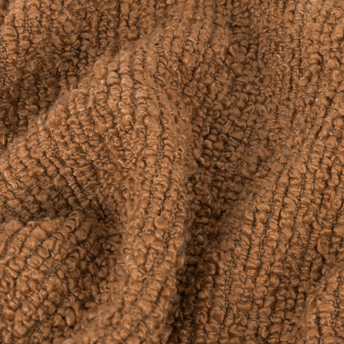 Close-up of the Candar Plain Polycotton Throw in ginger, showing its boucle-textured woven surface with tight looped fibres in a warm brown tone.