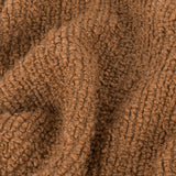Close-up of the Candar Plain Polycotton Throw in ginger, showing its boucle-textured woven surface with tight looped fibres in a warm brown tone.