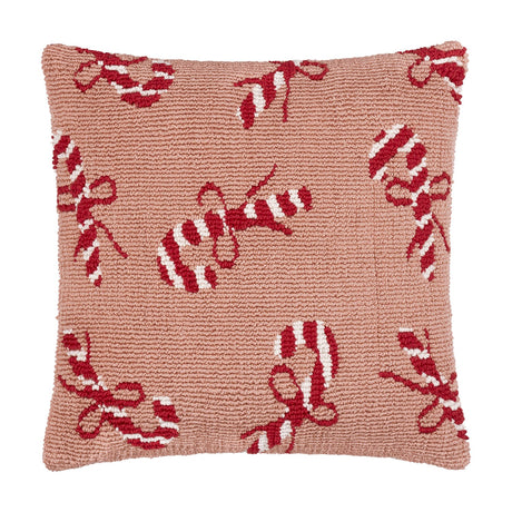 Square tufted cotton cushion in pink with a scattered red and white candy cane and bow pattern, shown on a plain white background.