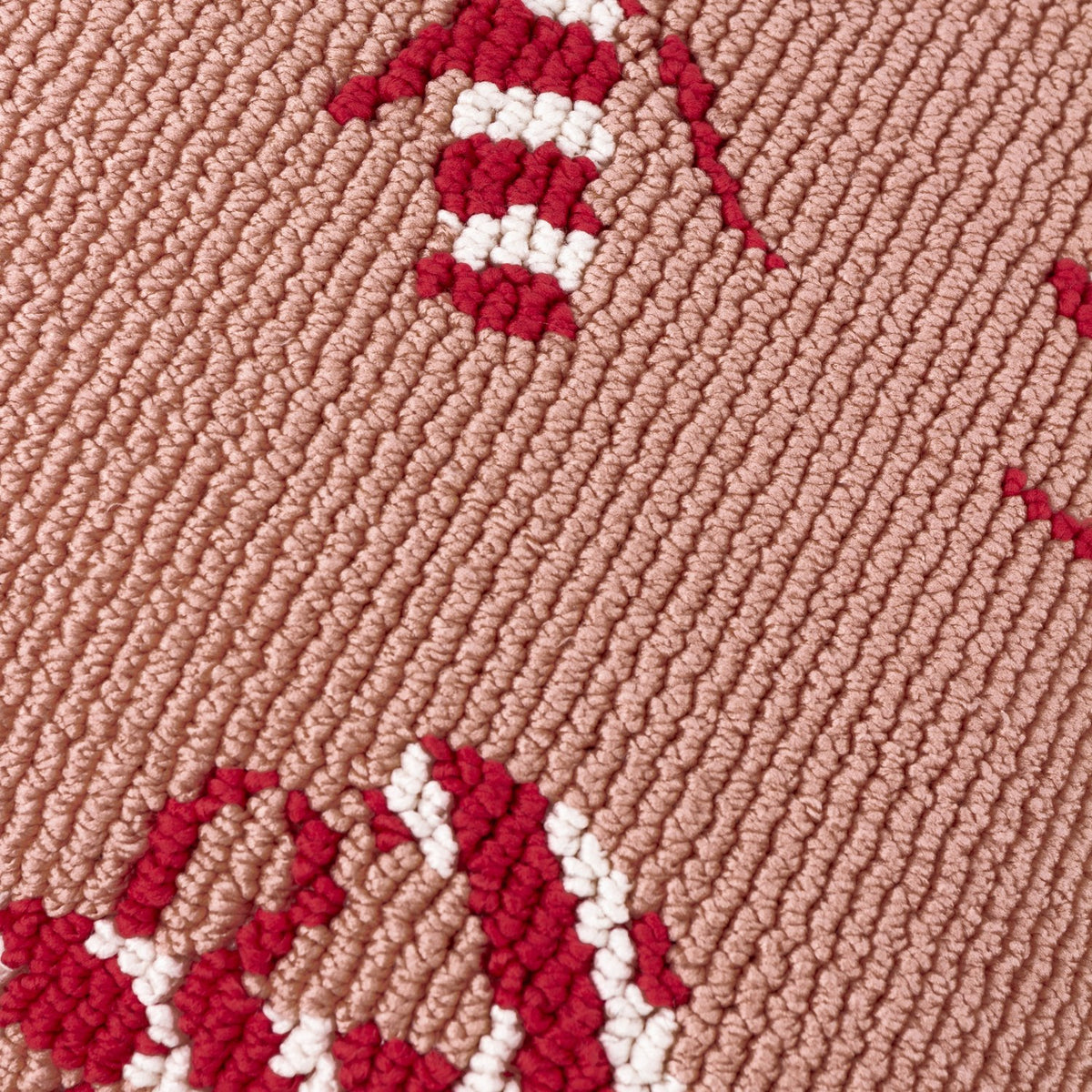 Close-up of the Candy Canes Tufted Cotton Cushion showing red and cream candy cane loops tufted against a pink ground, highlighting the raised textured pile.