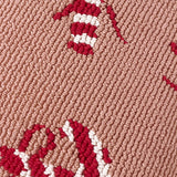 Close-up of the Candy Canes Tufted Cotton Cushion showing red and cream candy cane loops tufted against a pink ground, highlighting the raised textured pile.